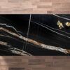 Noir St Laurent Porcelain worktop slab shown from above with black base and bold gold veining on a wood background