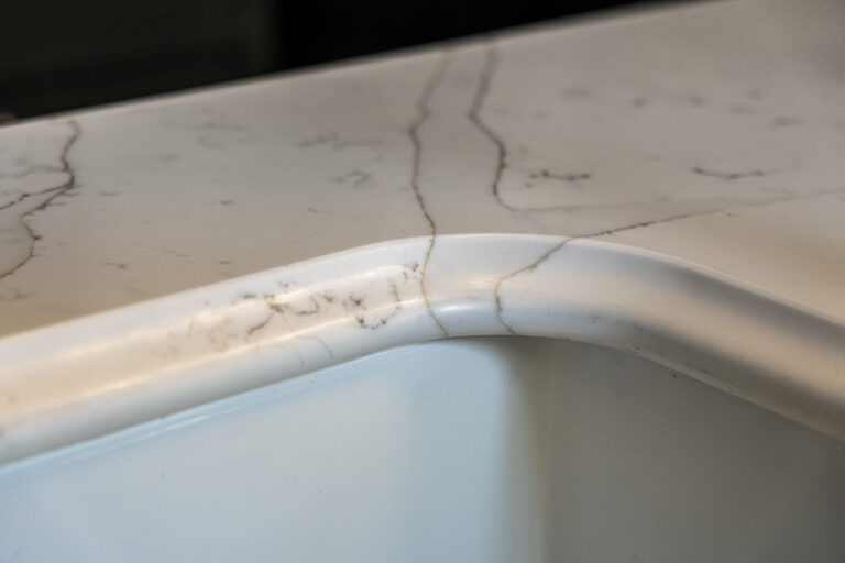 Gold Calacatta worktop with curved sink edge and warm veining