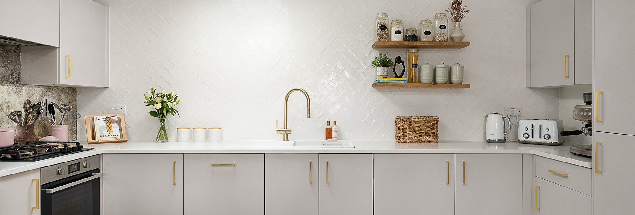 Modern kitchen fitted with Carrara Quartz worktops and brass accents