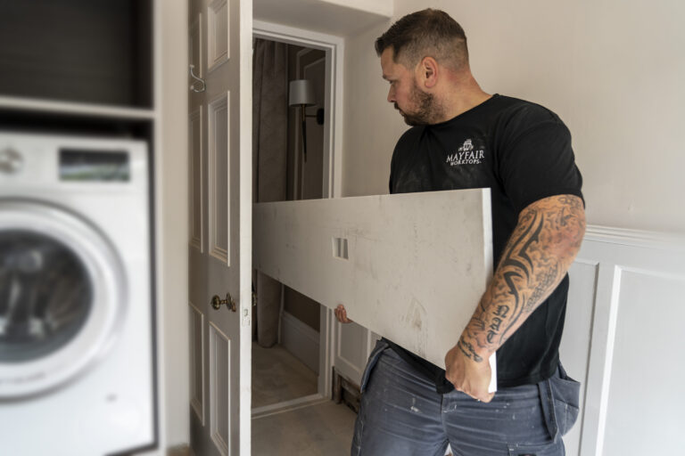 Stonemason making final adjustments during Carrara Quartz worktop installation